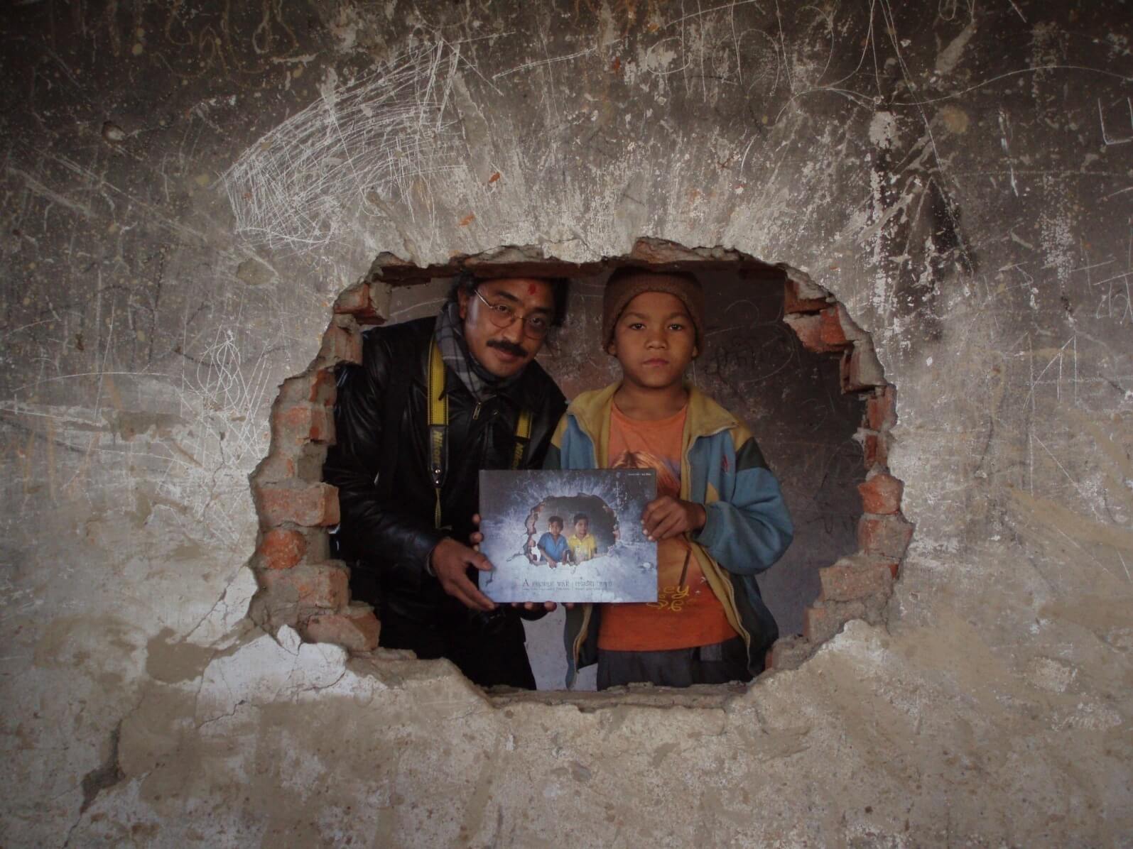 During the "People of War" Photo Exhibition tour, we came across some of the characters in the books. Here, Amrit Gurung presents a copy of the book to Hemanta at the exact spot in Motipur or Kailali where he had taken the picture five years previously.